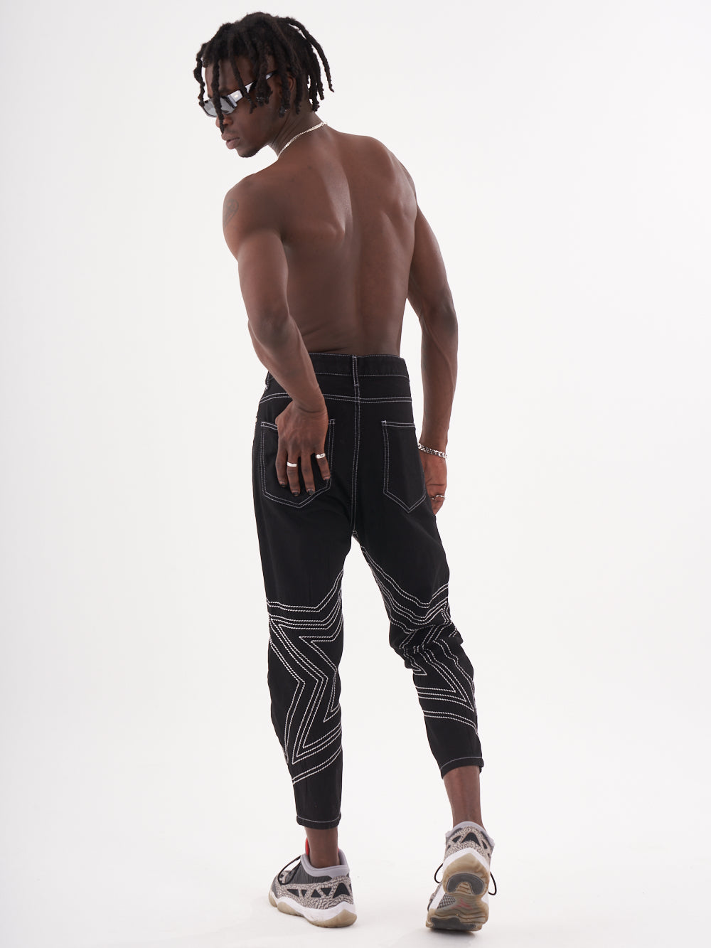 A man with dreadlocks wearing black joggers was holding STARDOM.