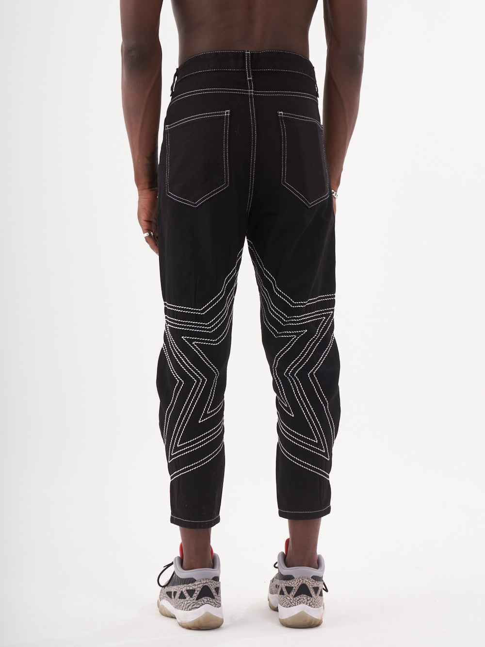 The back view of a man wearing STARDOM striped pants.