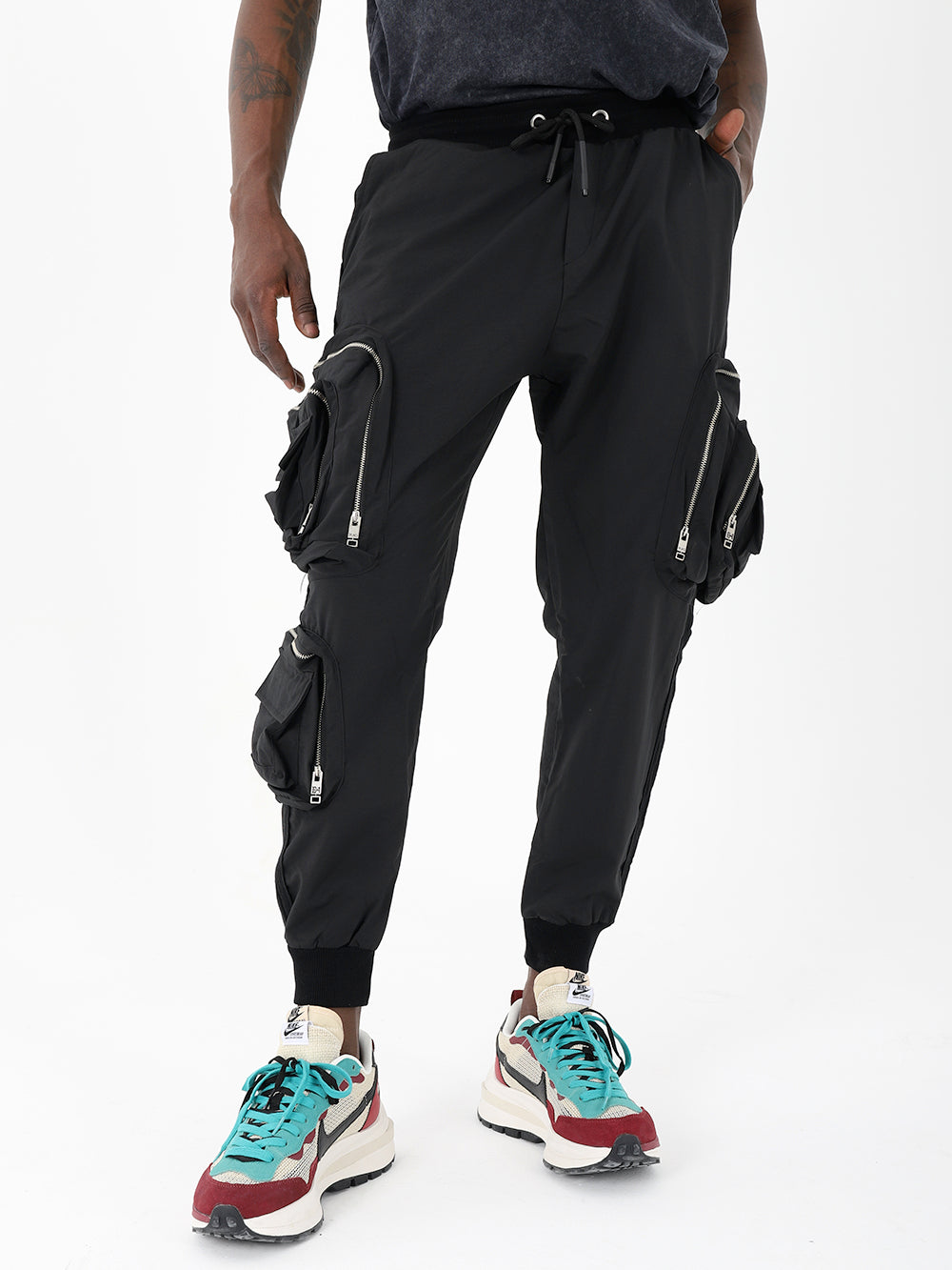 A man wearing black LAVANO JOGGERS and sneakers.