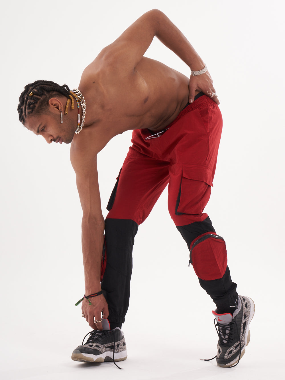 A man in RENEGADE | RED cargo pants is posing for a photo.
