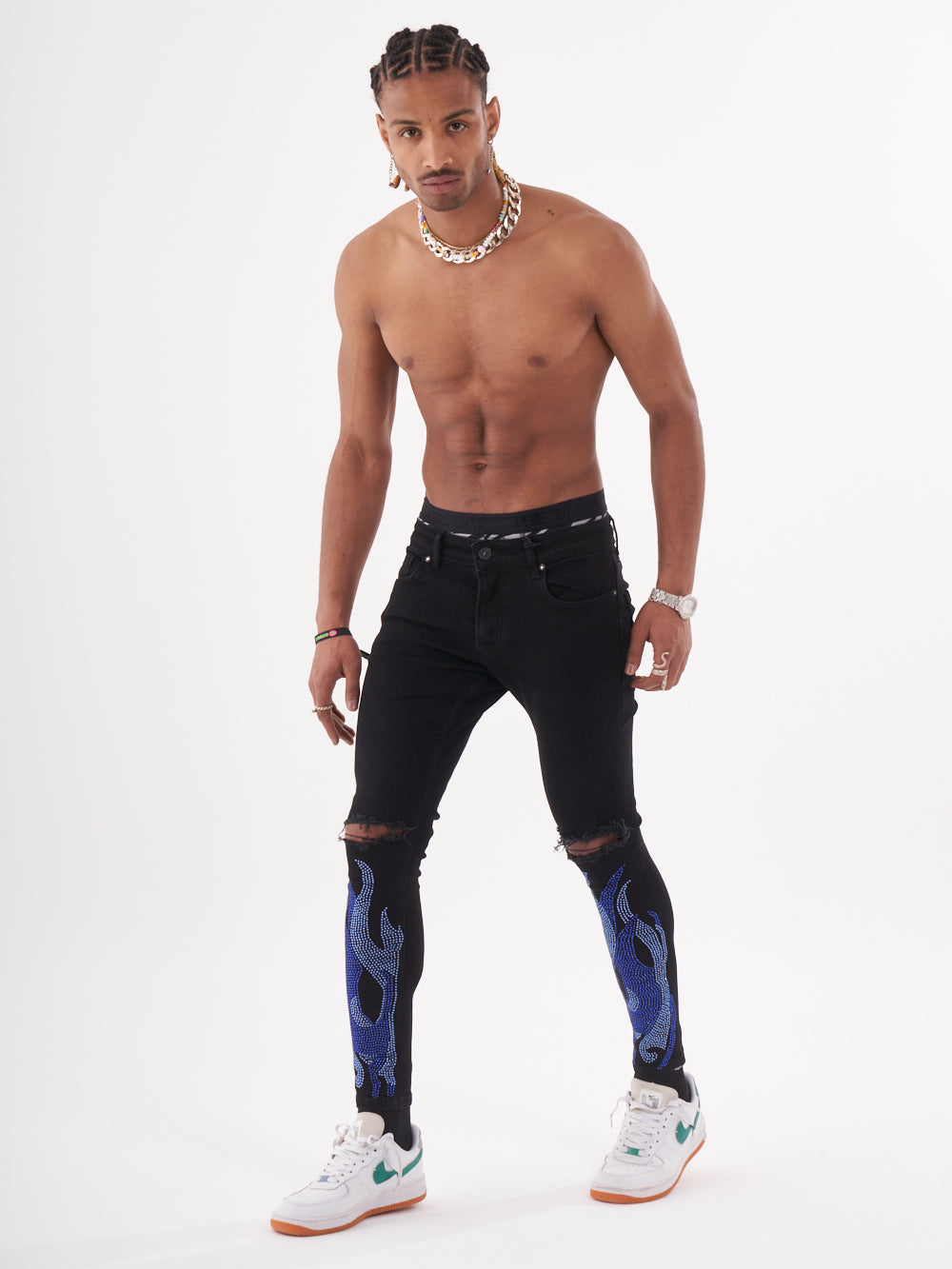 A man in black jeans with HELLFIRE | BLUE flames on them.