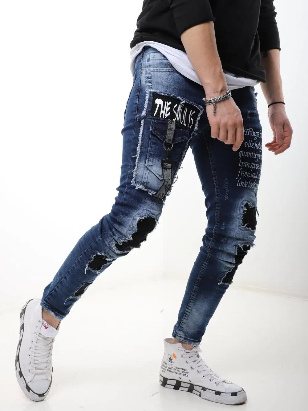 A man wearing ripped jeans and a BLUE SOUL t - shirt.