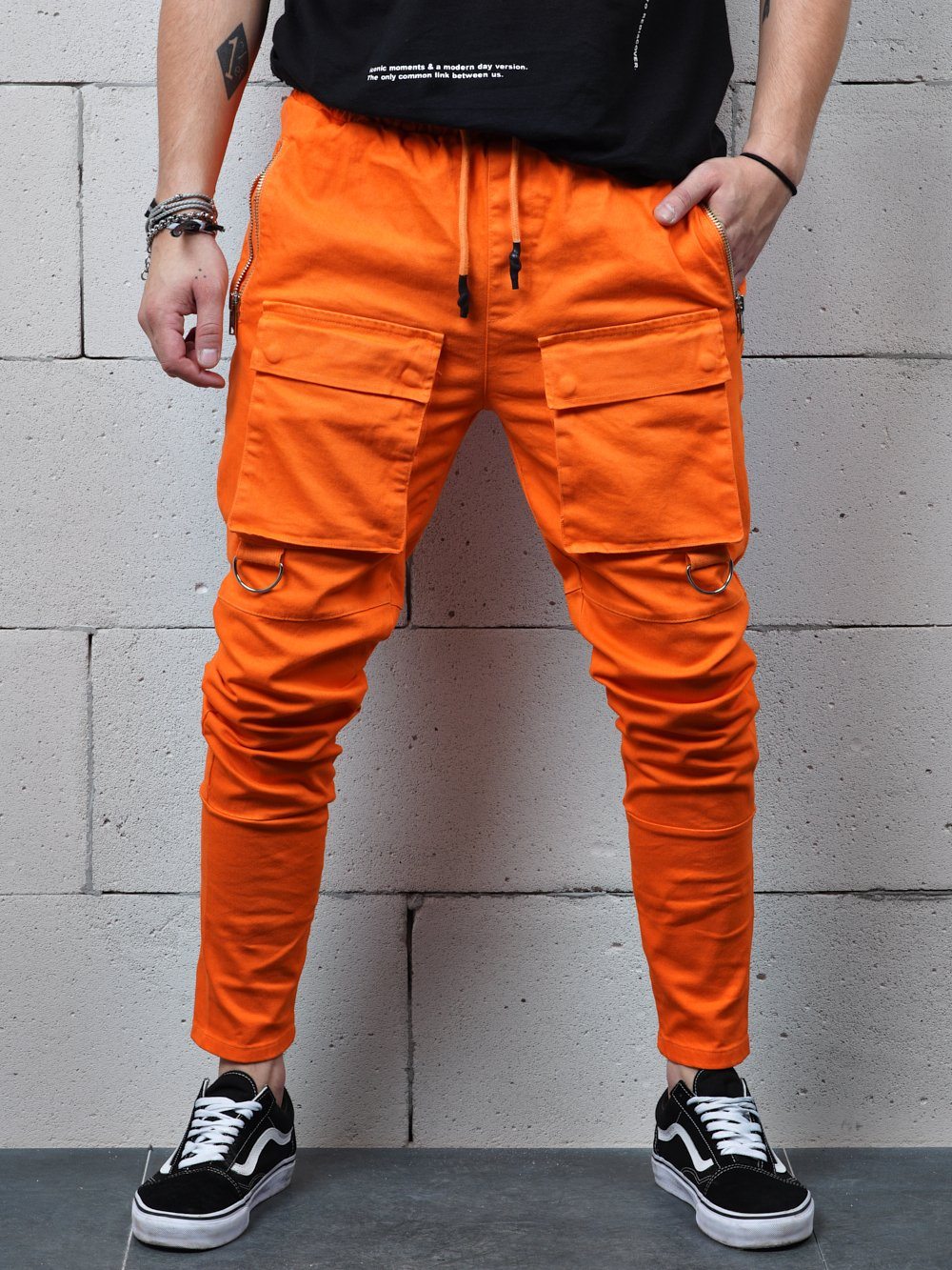 A man wearing ORANGE BRONX cargo pants and a black t-shirt.