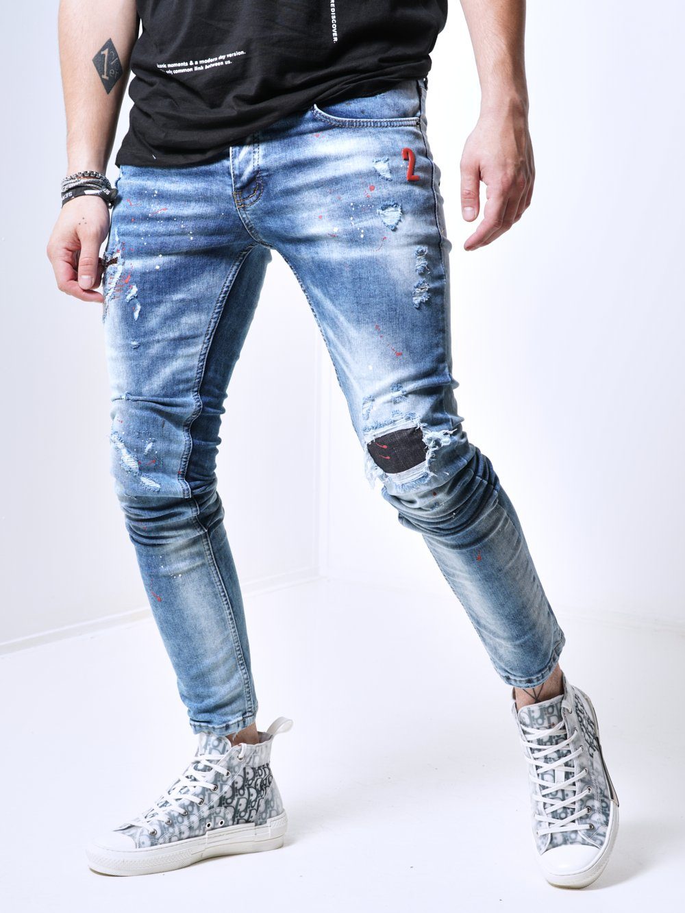 Side shot of a man sporting the skinny fit streetwear jeans called THE SPECIAL ONE with rips and patches by SERNES