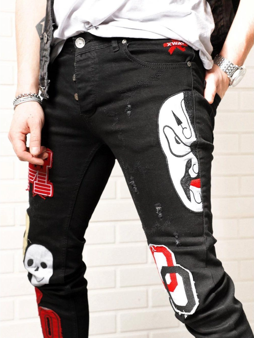 A man wearing a pair of black CLOWN CAR with a skull and crossbones on them.