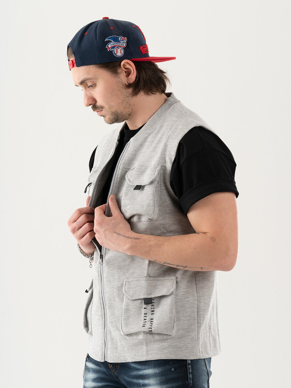 A man wearing a grey multi-pocket FREESPIRIT VEST with a hat.