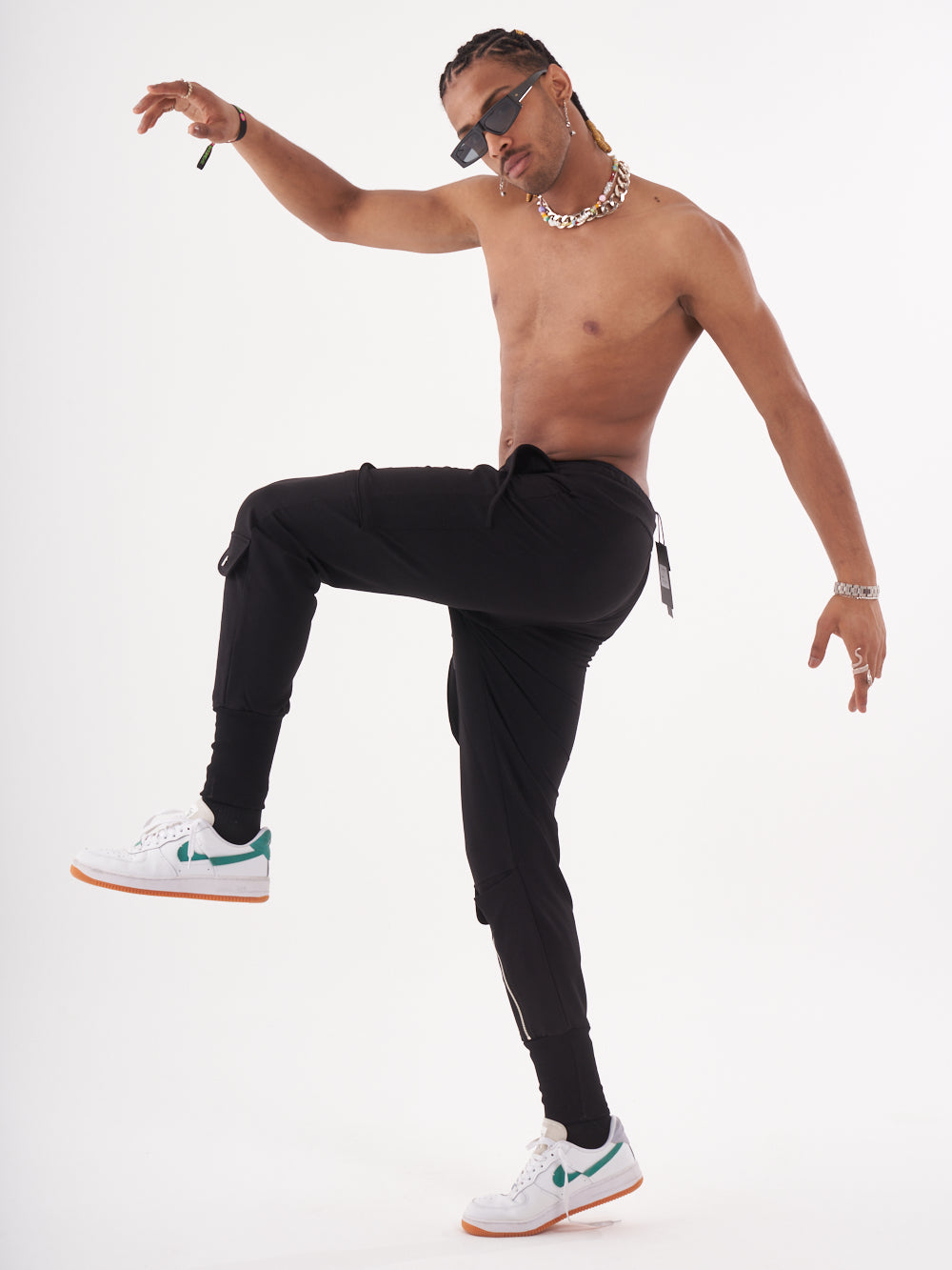 A man in GUERRILLA | BLACK jogging pant is posing for the camera.