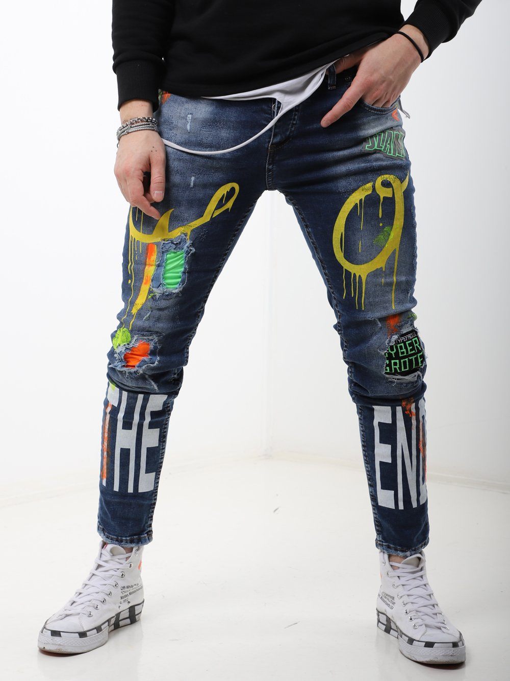 A man wearing a pair of MY WAY jeans with graffiti on them.