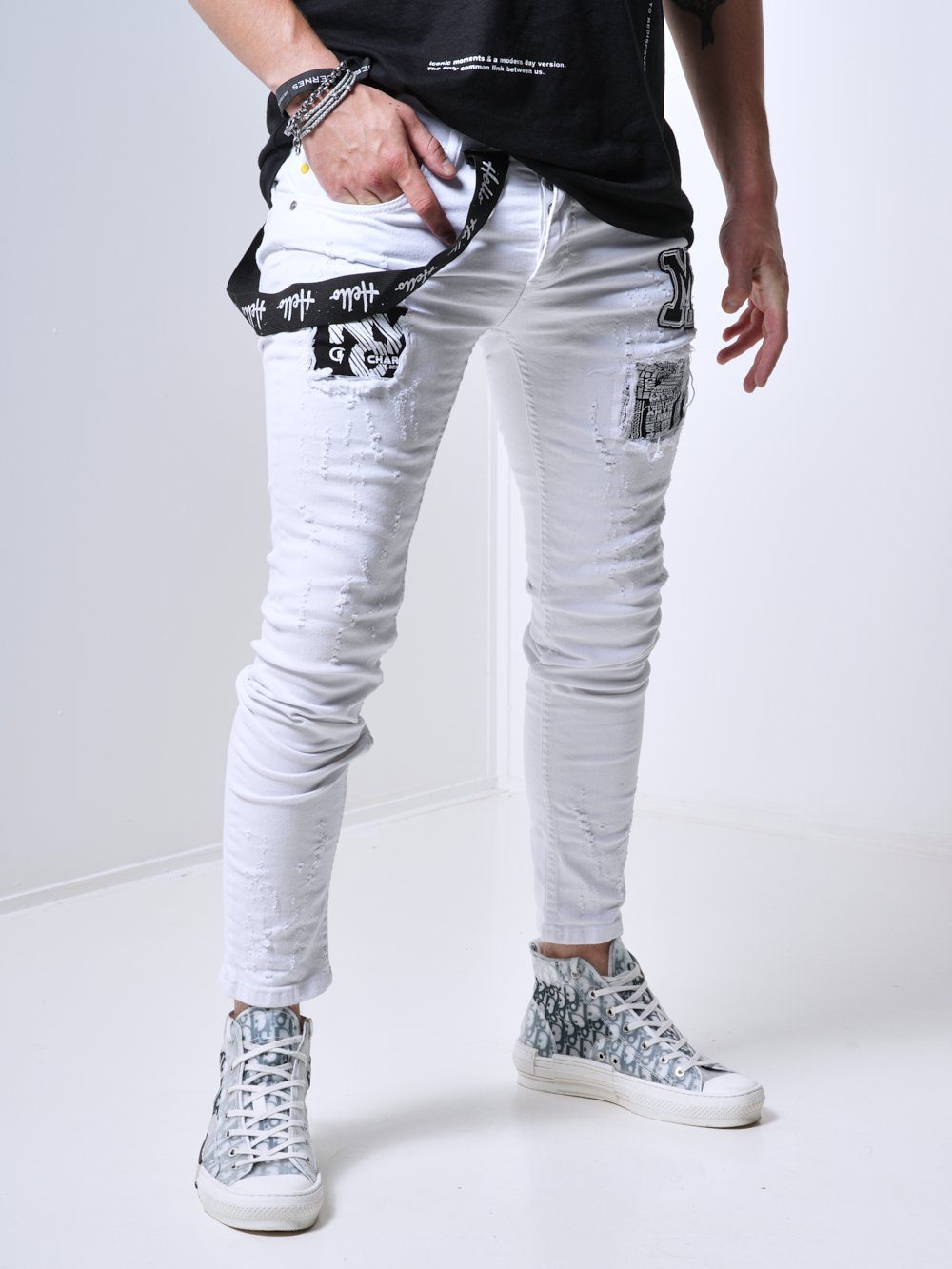 A man wearing MASSIVE skinny fit white jeans and a black t-shirt.