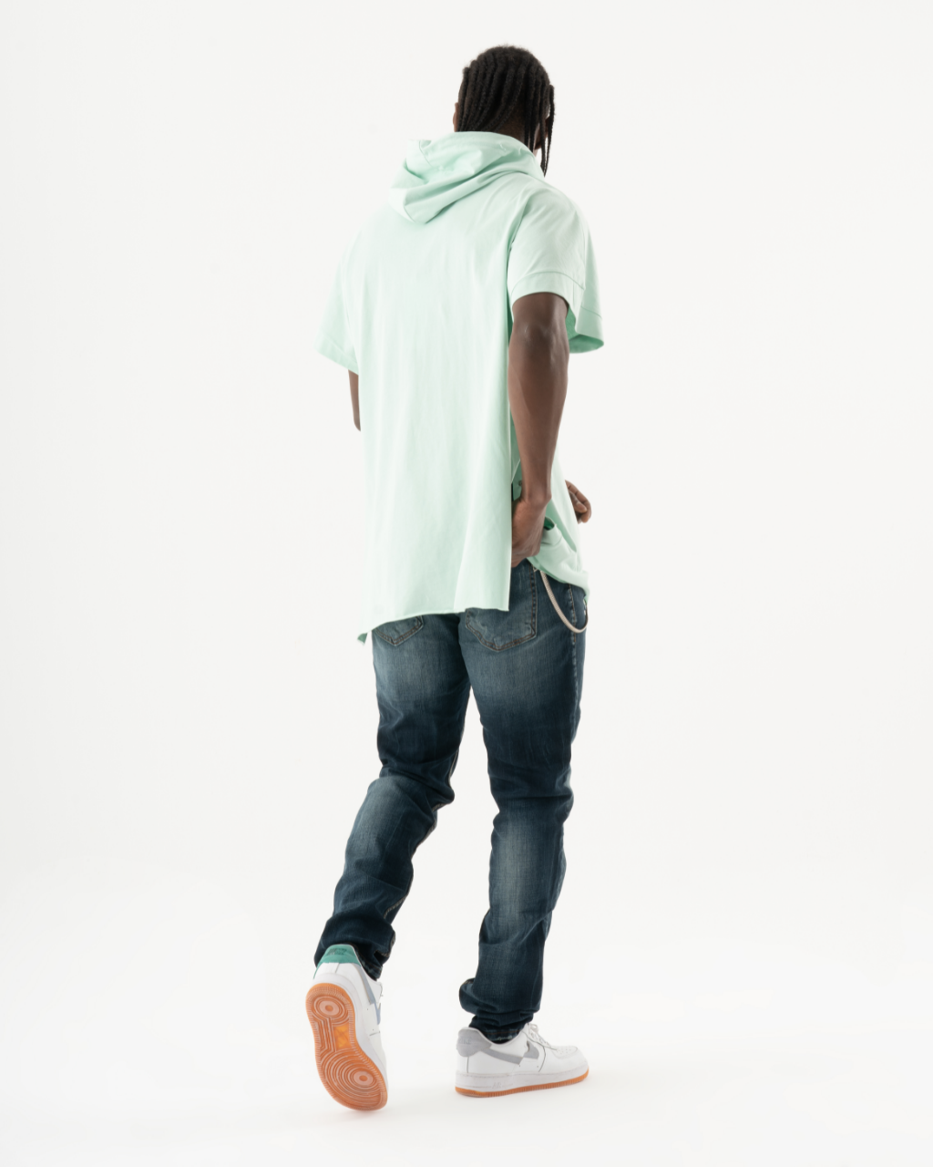 A man wearing a green KUDOS hoodie and jeans.