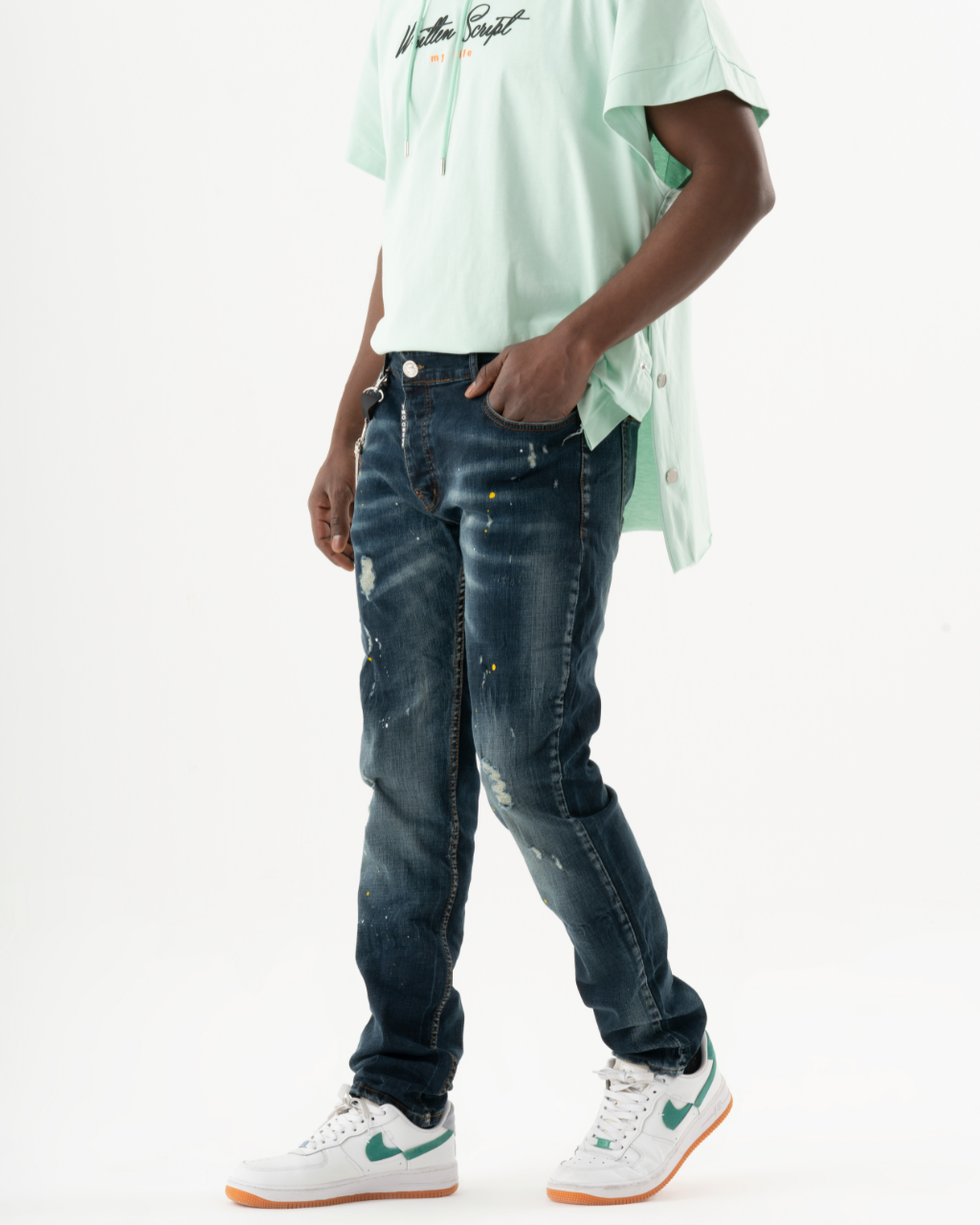 A man wearing a KUDOS t - shirt and jeans.