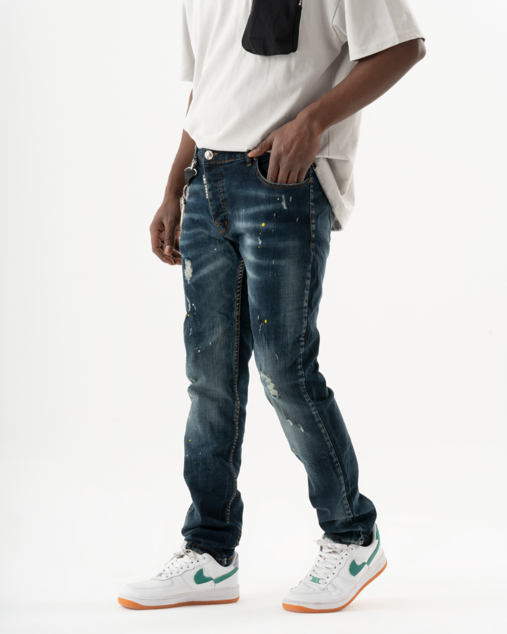 A man wearing a KUDOS t-shirt and jeans.