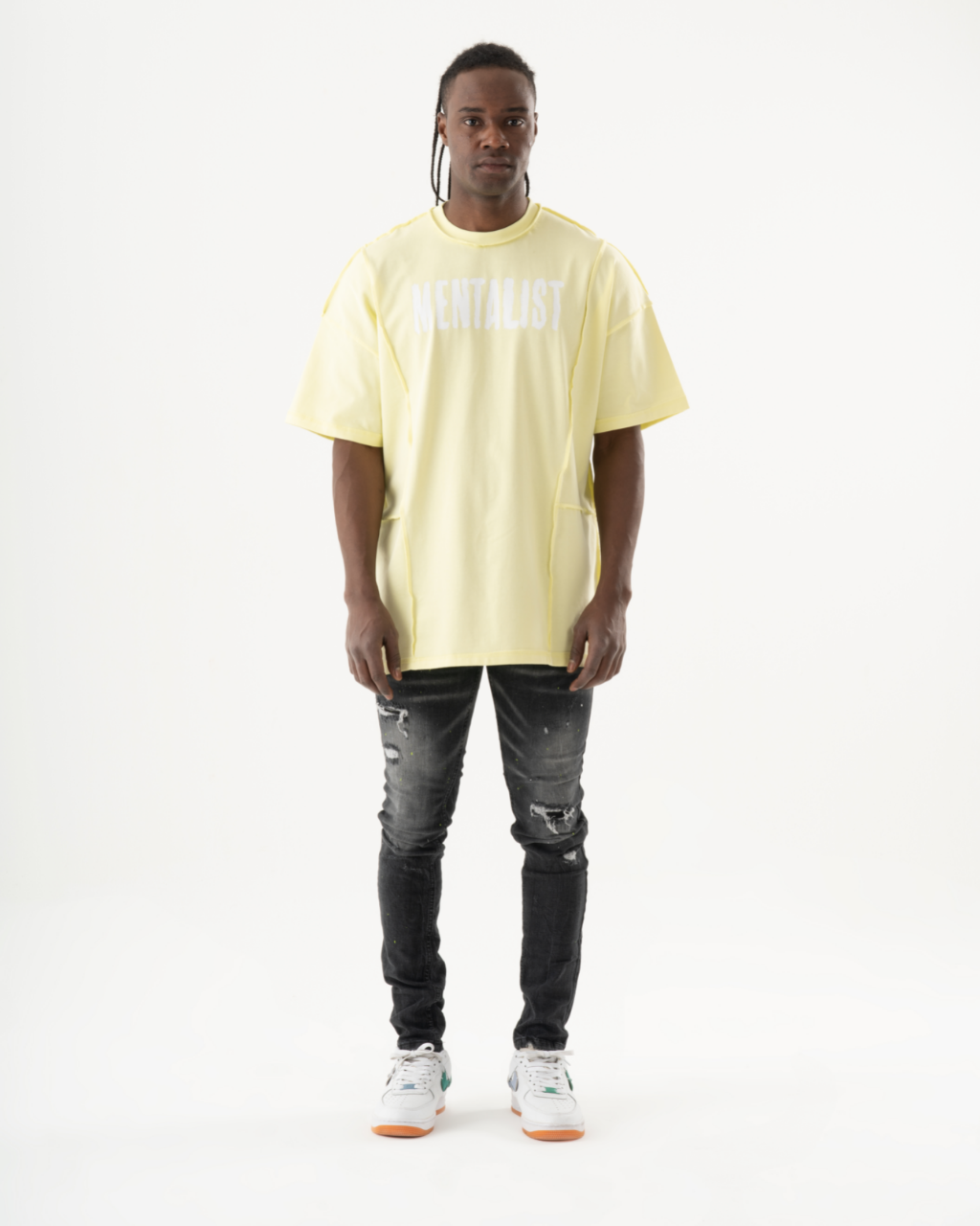 A man wearing an INKLING t-shirt and black skinny jeans.