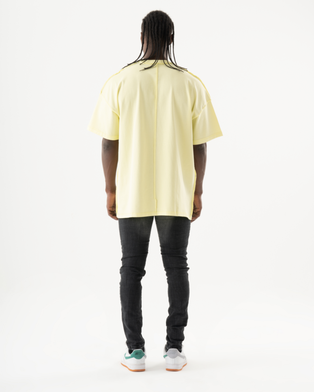 The back of a man wearing an INKLING t-shirt and skinny fit jeans.