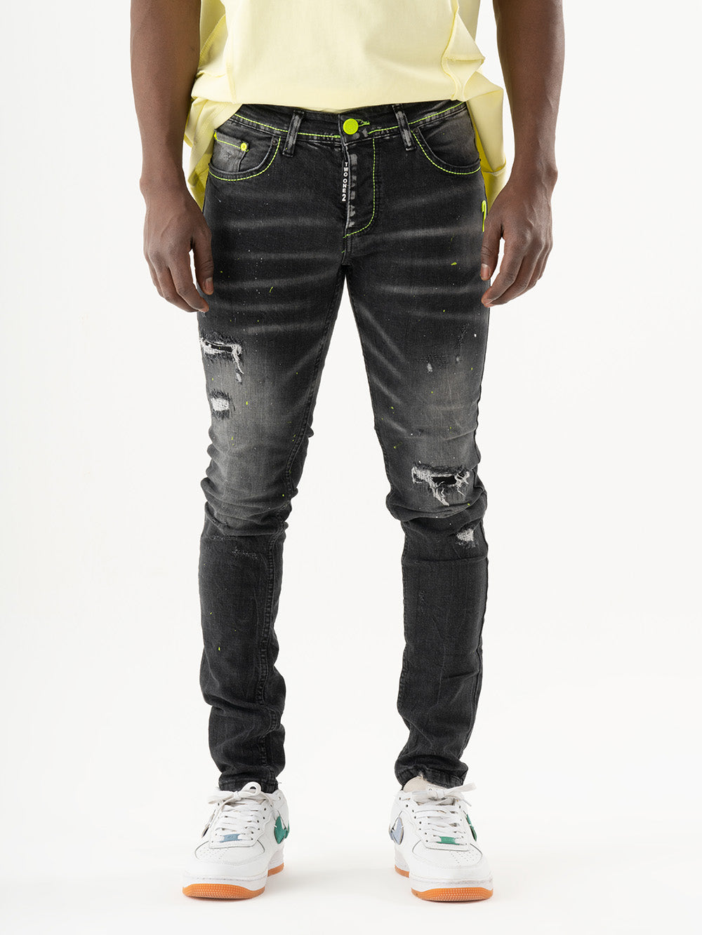 A man in INKLING skinny fit jeans and a yellow t-shirt exhibiting mens streetwear style.