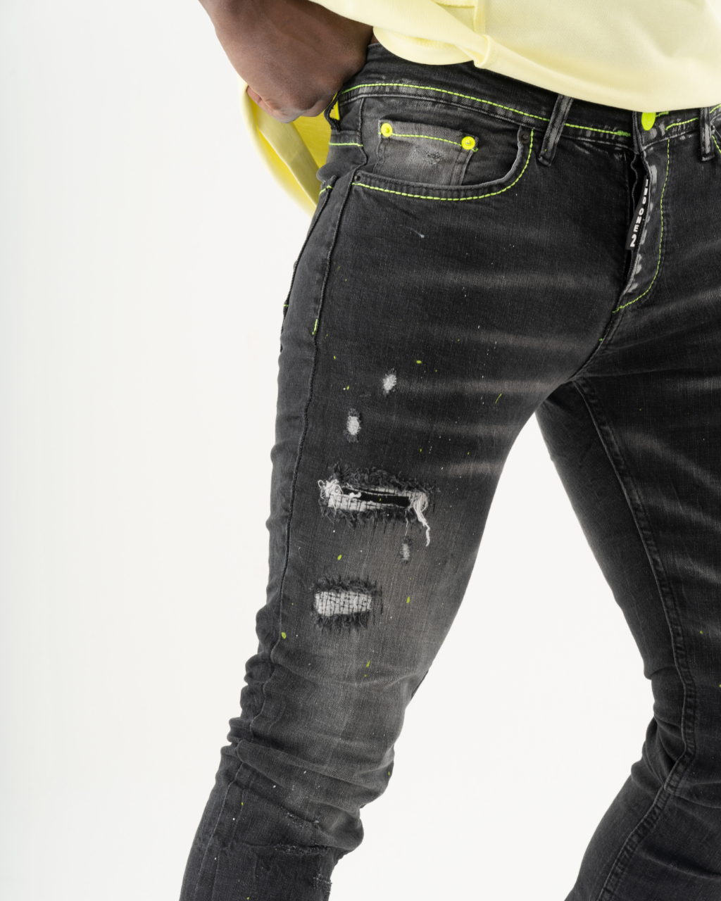 A man in INKLING skinny fit black jeans and a yellow t-shirt.