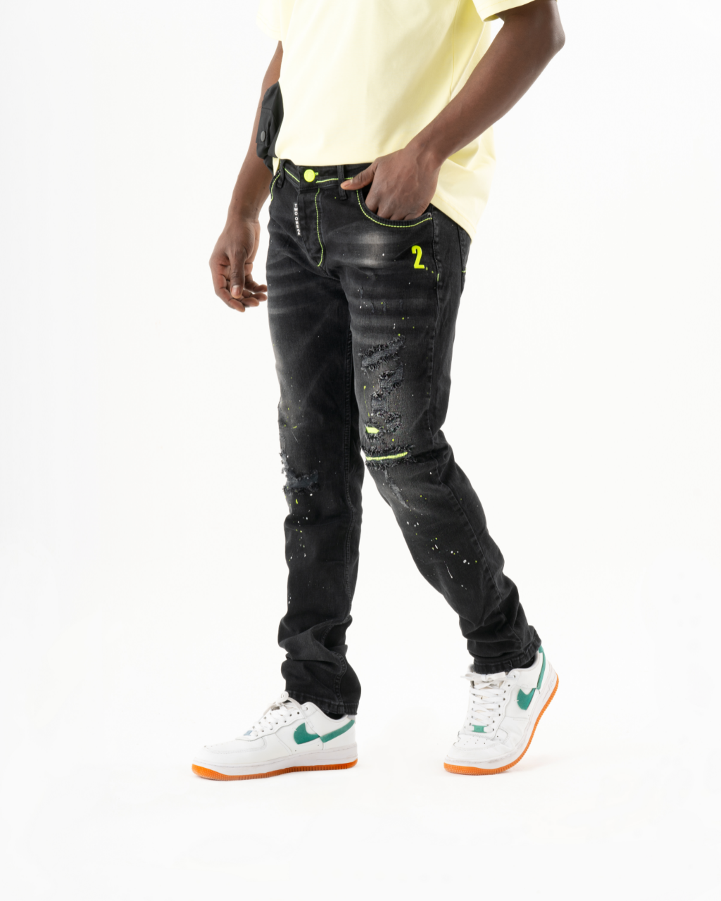 A man wearing ripped skinny-fit black jeans and a white TWILIGHT t-shirt.