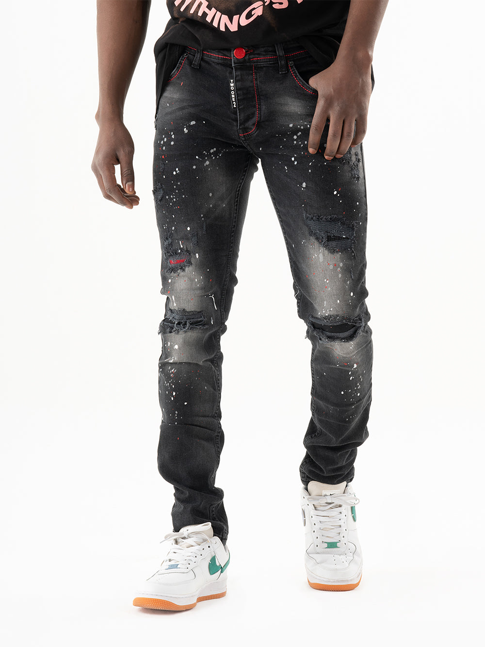 A man wearing HOTSPOT black jeans and a white t-shirt.