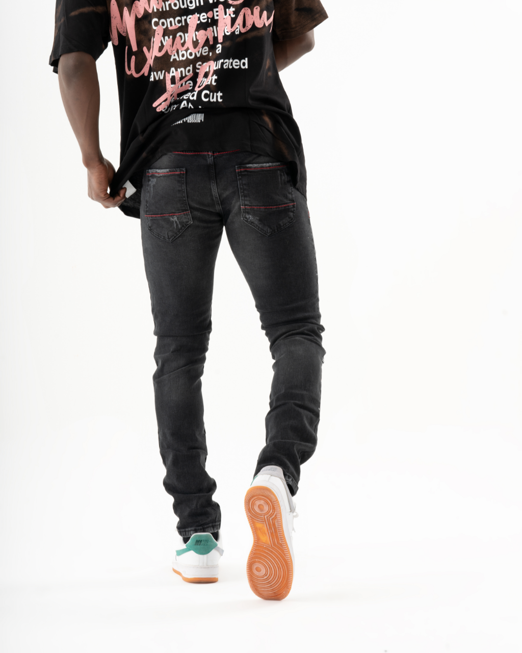 A man wearing ripped jeans and a black t-shirt. Product Name: HOTSPOT