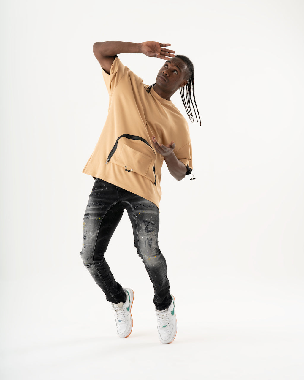 A man in an ENRAGE skinny fit tan hoodie and jeans doing a flip.