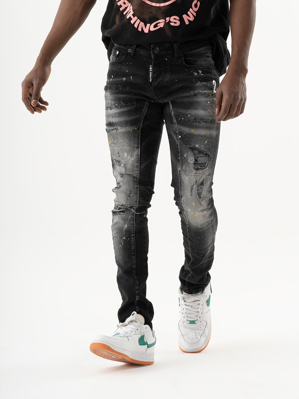 A man wearing black skinny fit ENRAGE jeans made of elastic fabric and an ENRAGE smooth feel t-shirt.