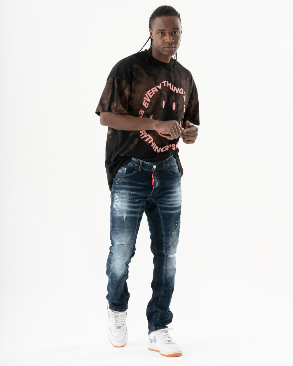 A man wearing a INCOGNITO t - shirt and jeans.