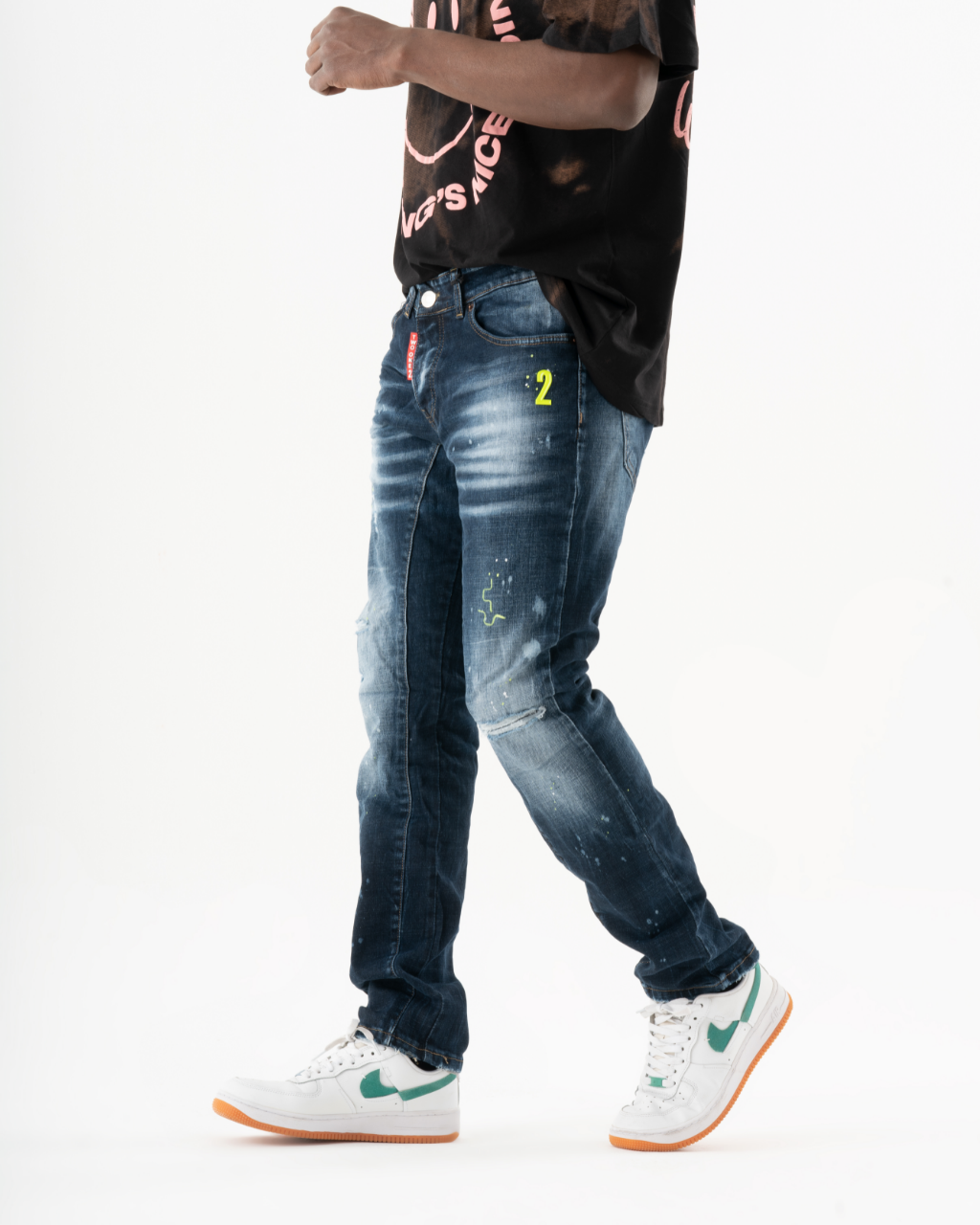 A young man wearing an INCOGNITO t-shirt and jeans.