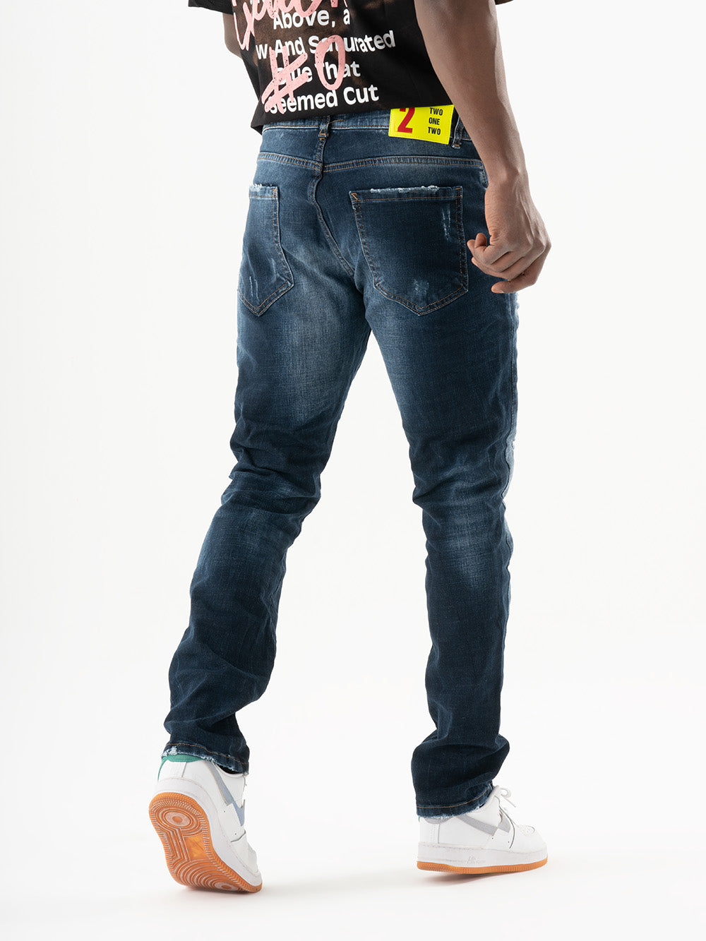 The back of a man wearing INCOGNITO jeans and a t-shirt.