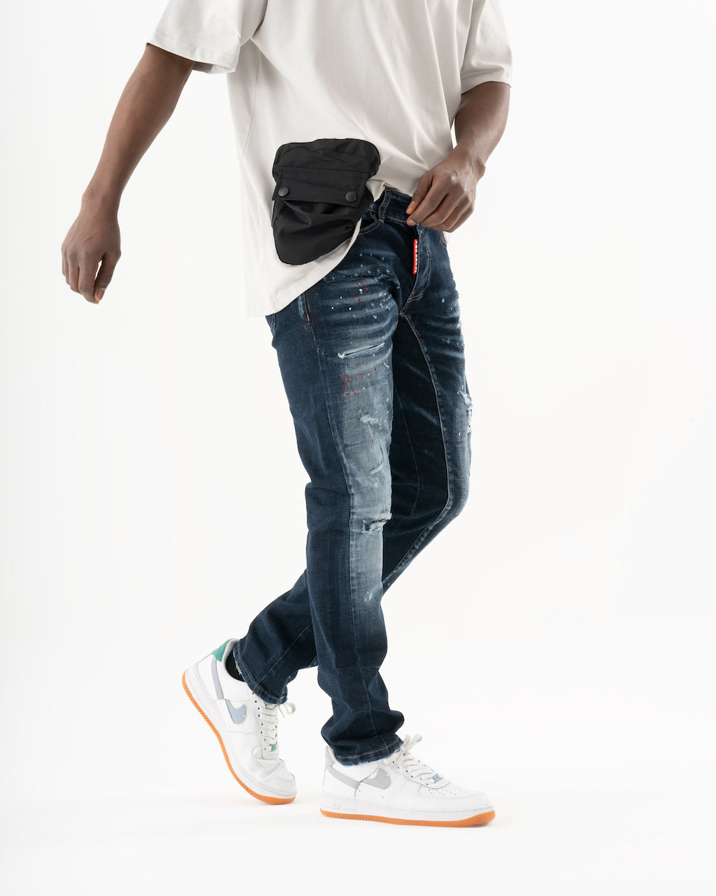 A man wearing jeans and a black STARLIGHT fanny pack.