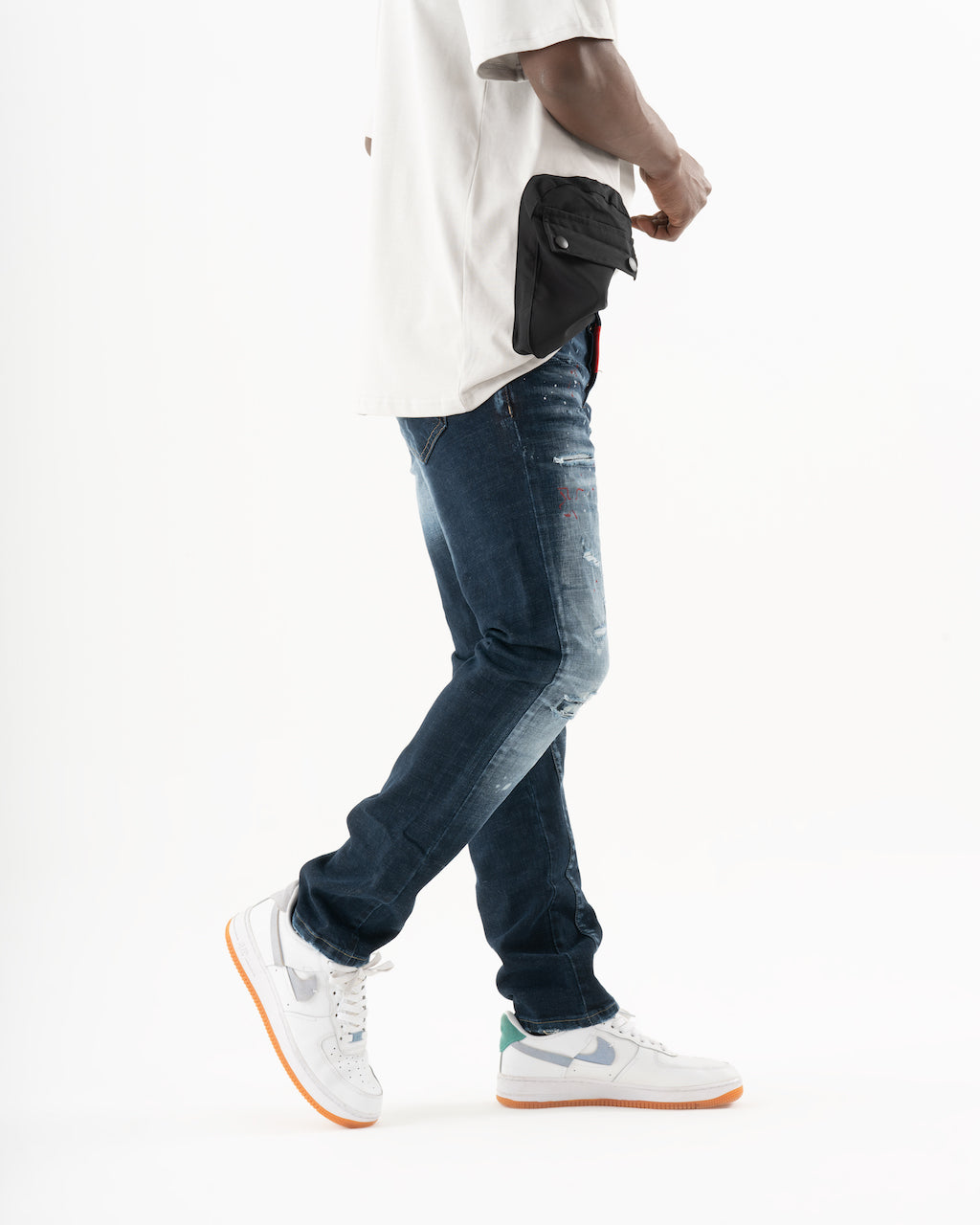 A man wearing jeans and a white STARLIGHT fanny pack.