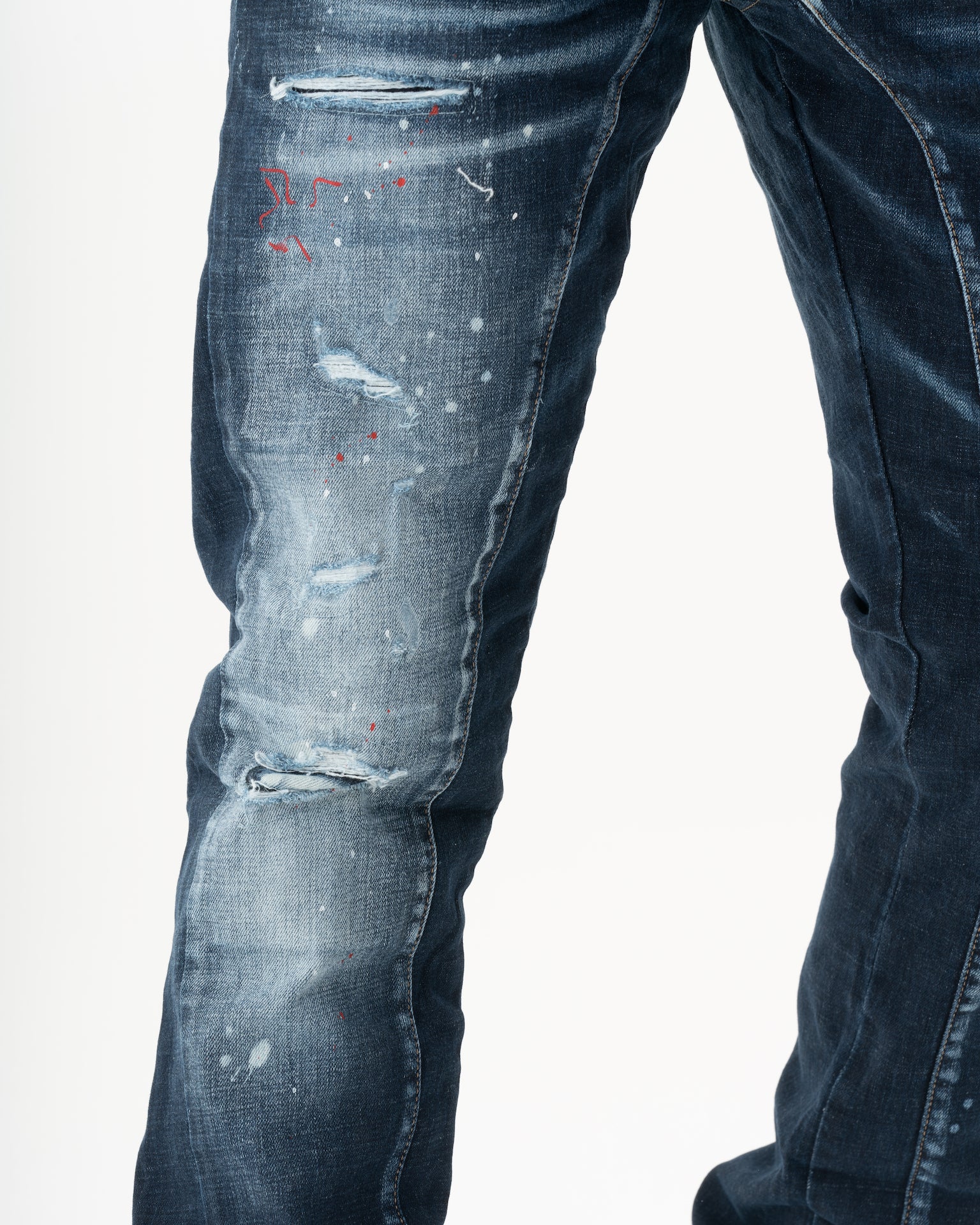 A man wearing a pair of STARLIGHT with paint splatters on them.