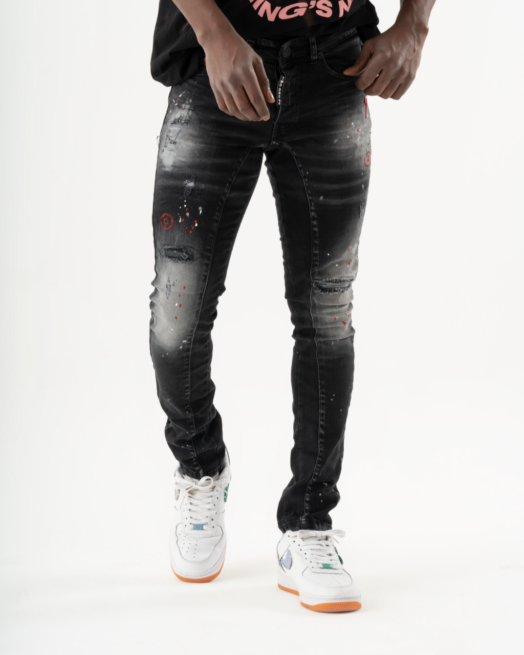 A man wearing ripped THUNDERBIRD jeans and a white t-shirt.