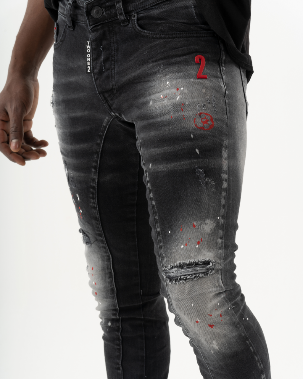 A man wearing a pair of THUNDERBIRD jeans with added stretch and red paint on them.