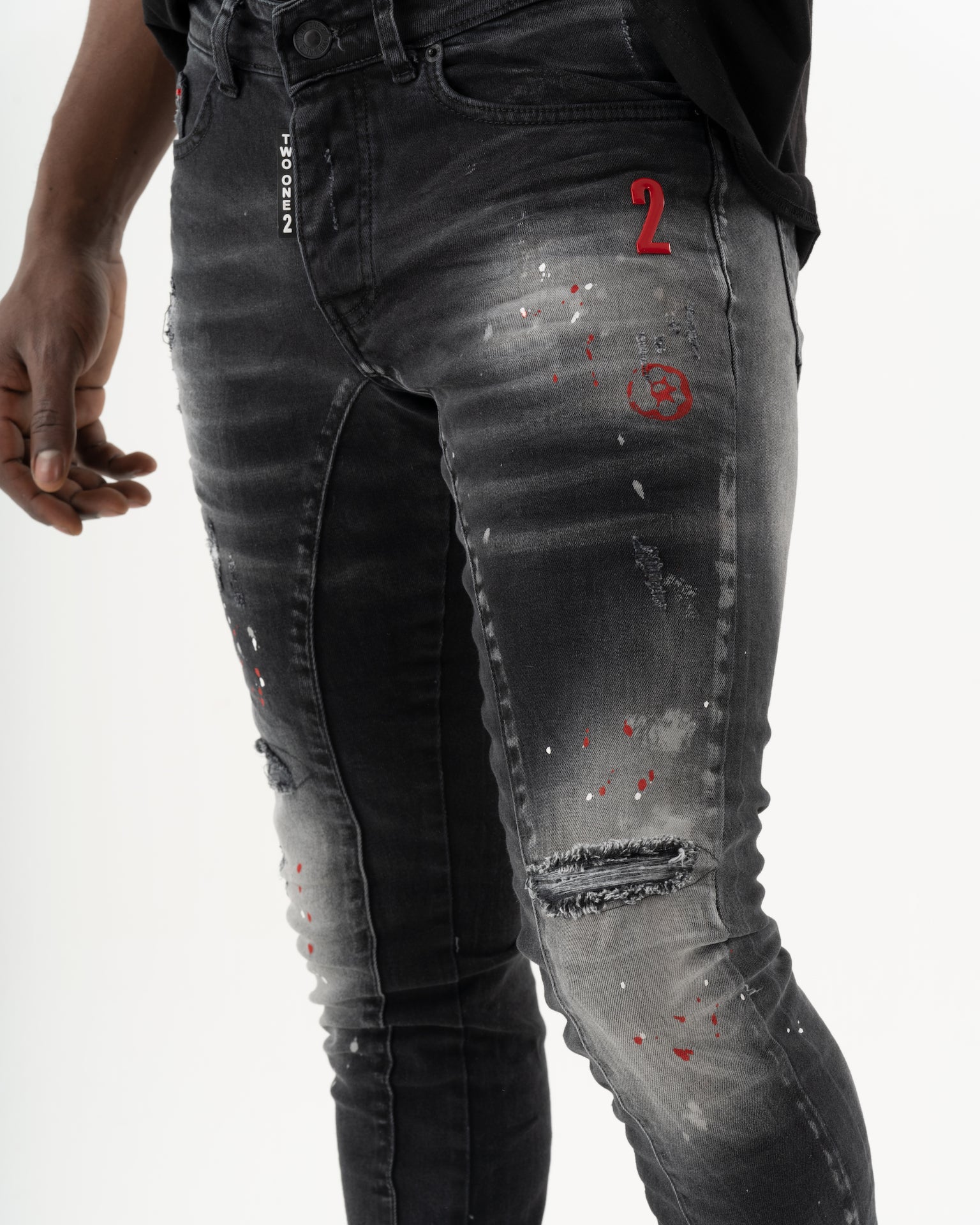 A man wearing a pair of THUNDERBIRD with added stretch and red paint on them.