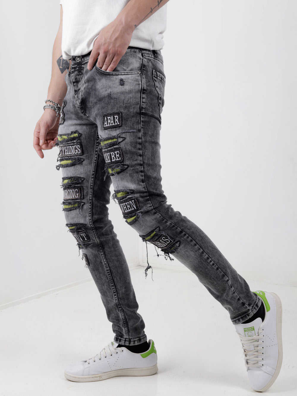 A man wearing IMPROPER jeans and a white t-shirt.