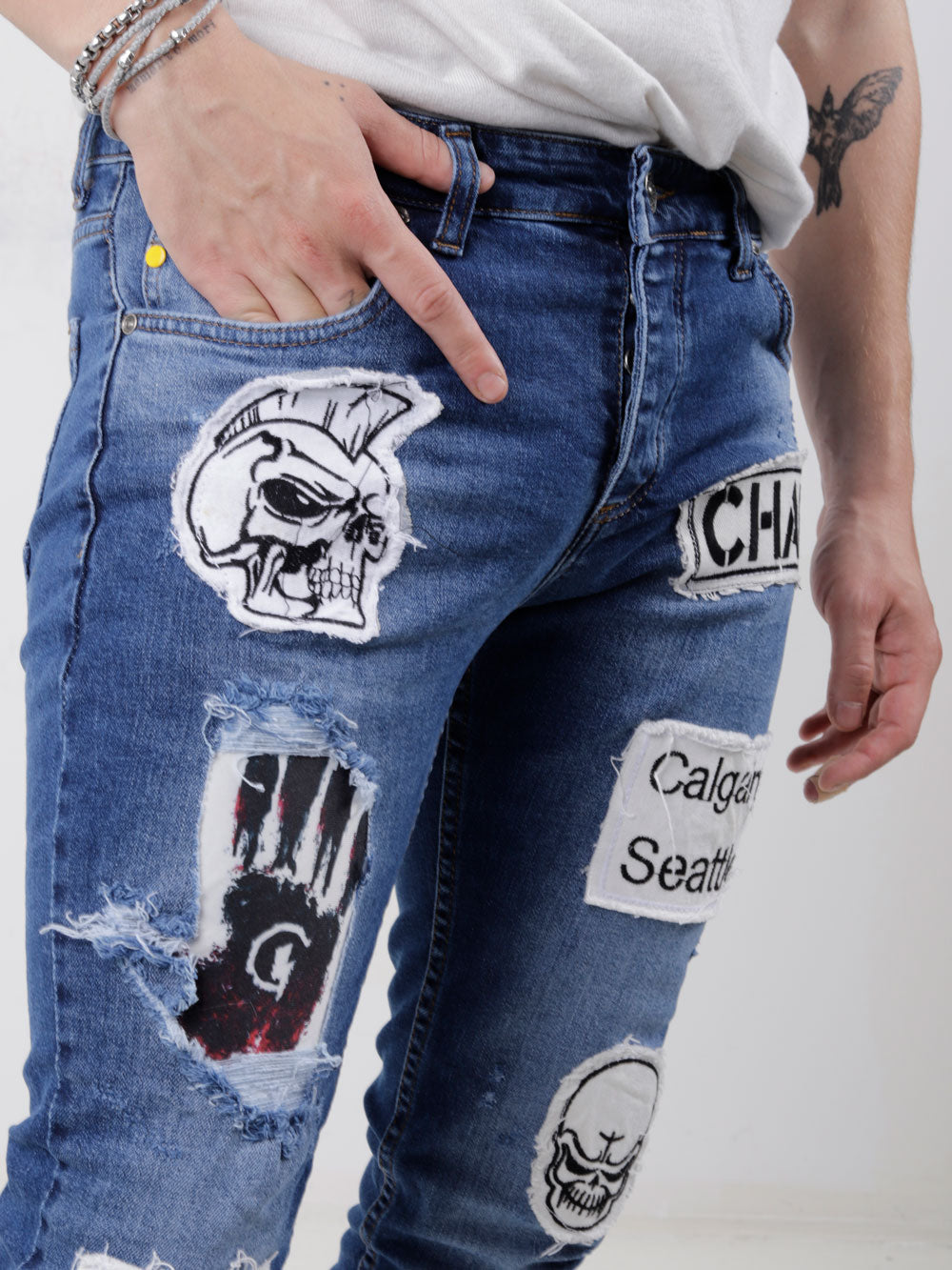 A man wearing a pair of HEADSTONE with patches on them.