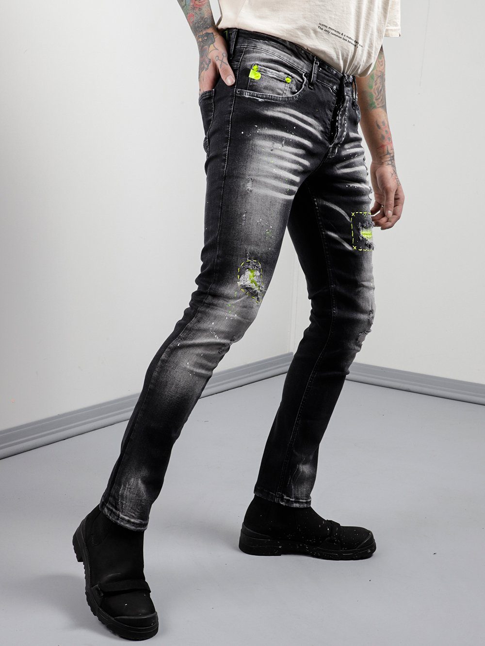 A man in NEON TALK jeans with a tattoo on his arm.