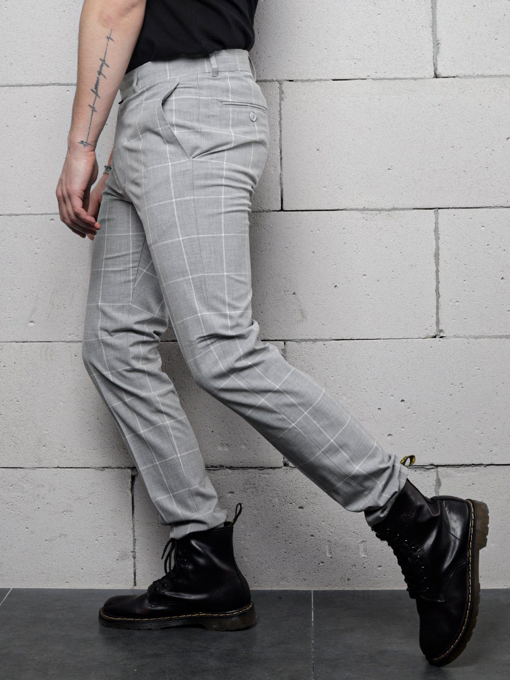 A man wearing skinny fit black boots and ICED AMERICANO PANTS jeans.