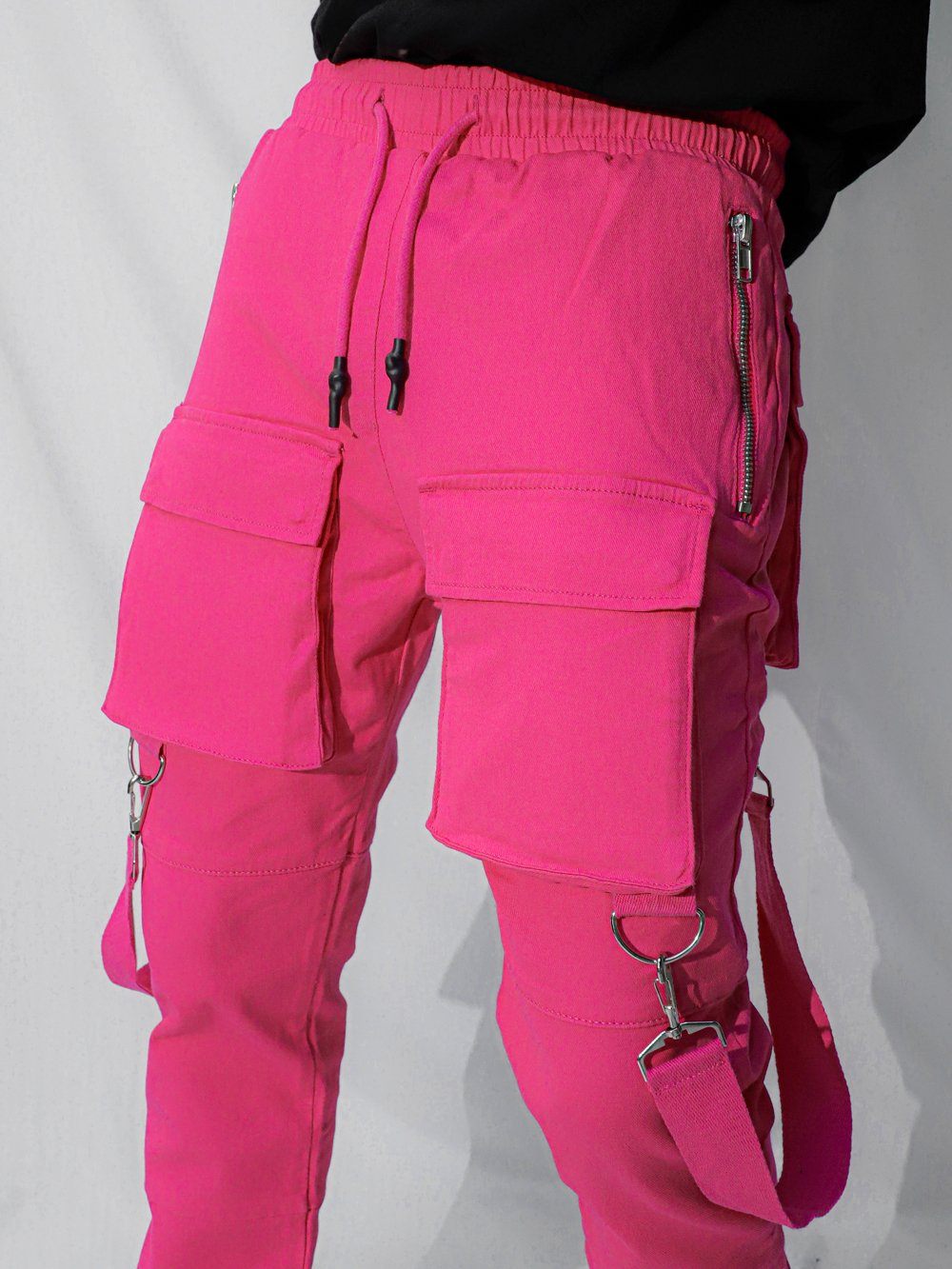 A man wearing PINK BRONX cargo pants with zippers.