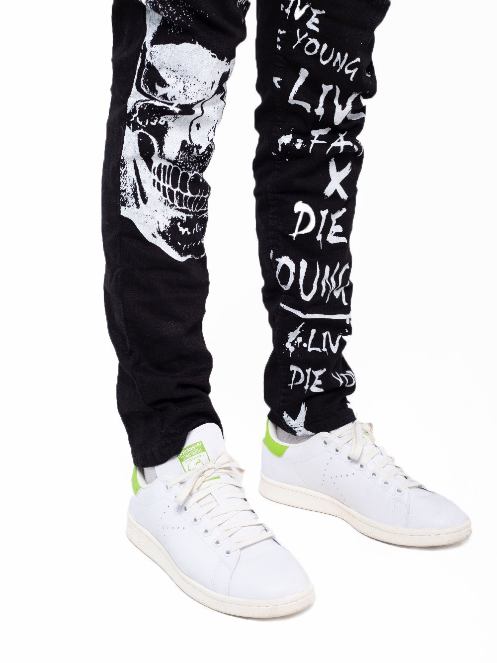 A man wearing a pair of DEAN jeans with graffiti on them.