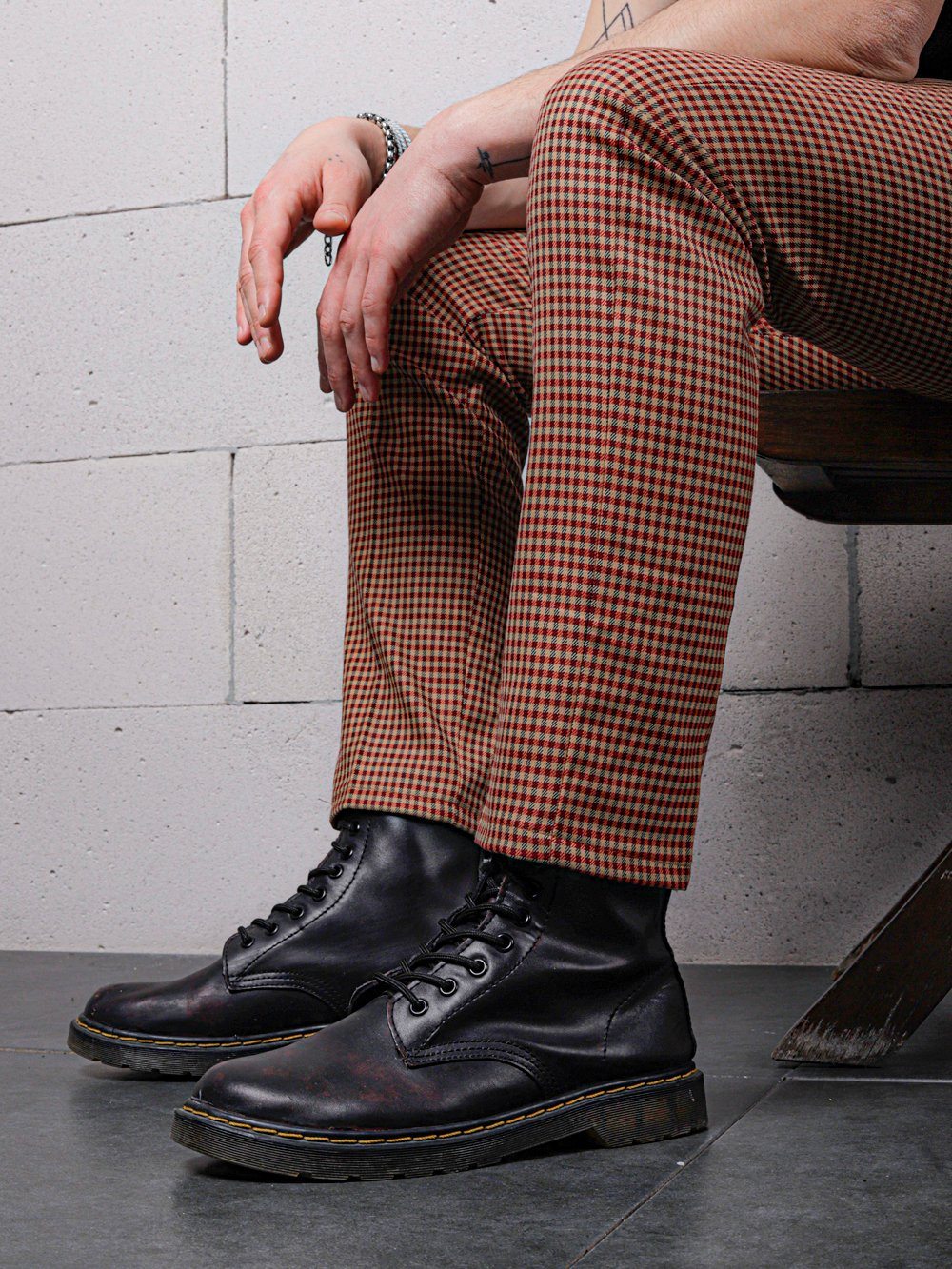 A skinny man wearing JAVA CHIP PANTS sitting on a chair.