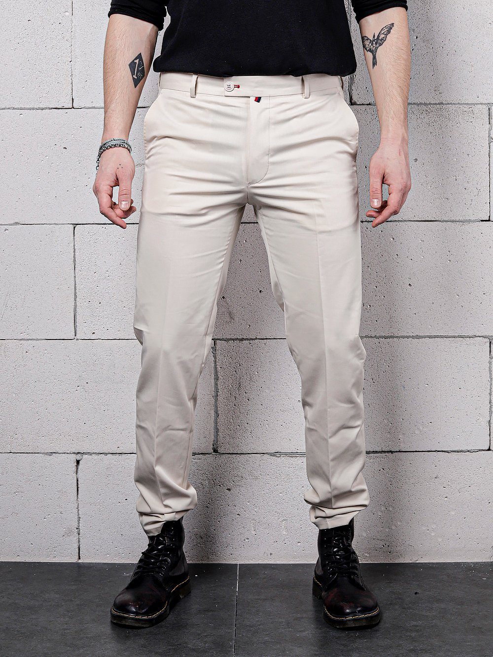 A man wearing beige color Vanilla Pants by SERNES Streetwear with a black shirt