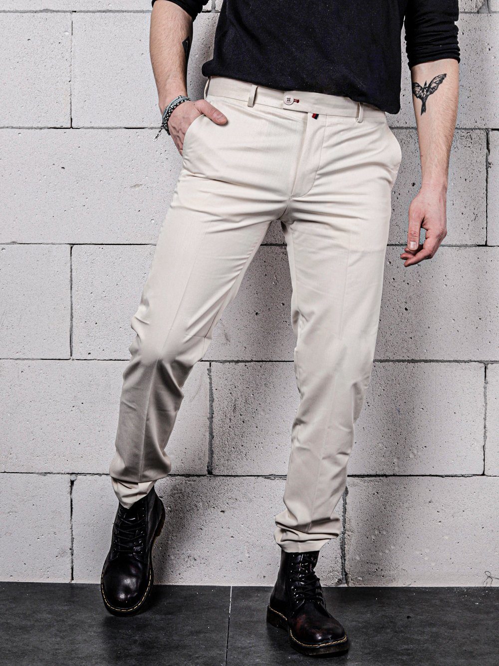 A man wearing beige color Vanilla Pants by SERNES Streetwear with a black shirt