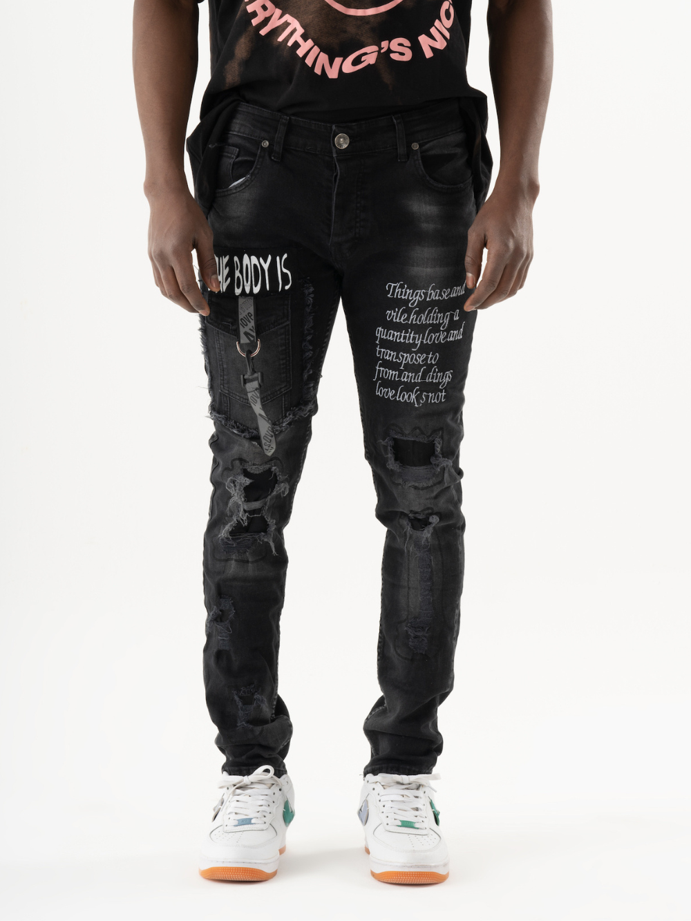 A man wearing a ONE SOUL black t-shirt and black jeans.