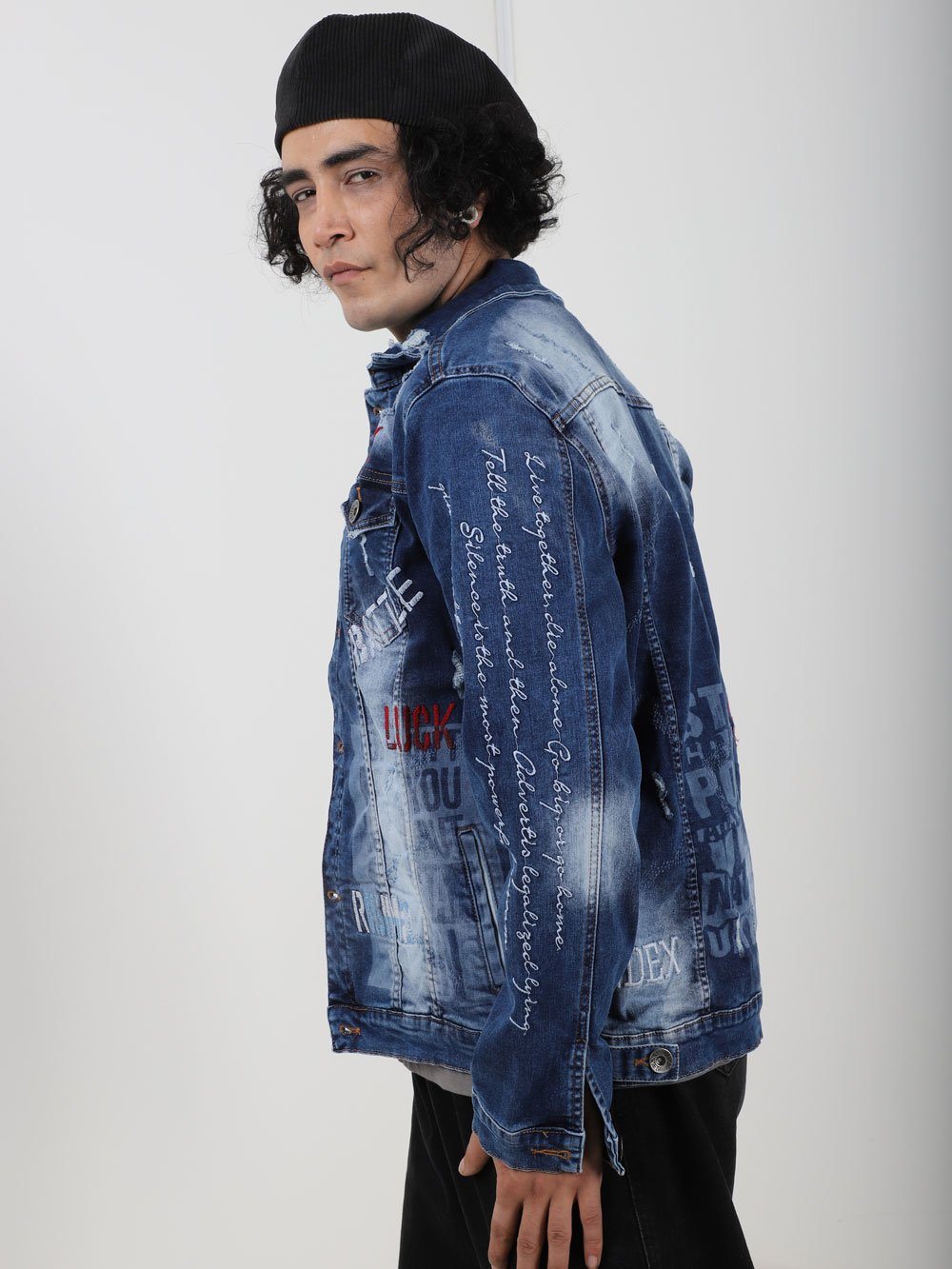 A man wearing THE VETERAN denim jacket with writing on it.