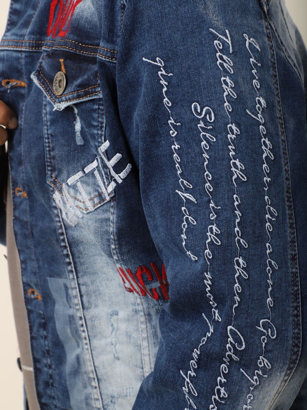 A man wearing a denim jacket with THE VETERAN written on it.