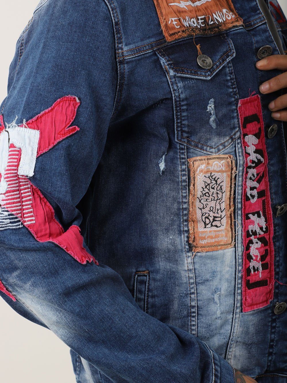 A man wearing THE VETERAN denim jacket with patches on it.