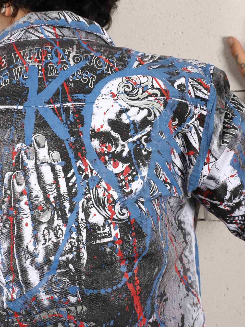 A man wearing a LA VIDA LOCA denim jacket with a skull on it and LA VIDA LOCA skinny fit jeans.