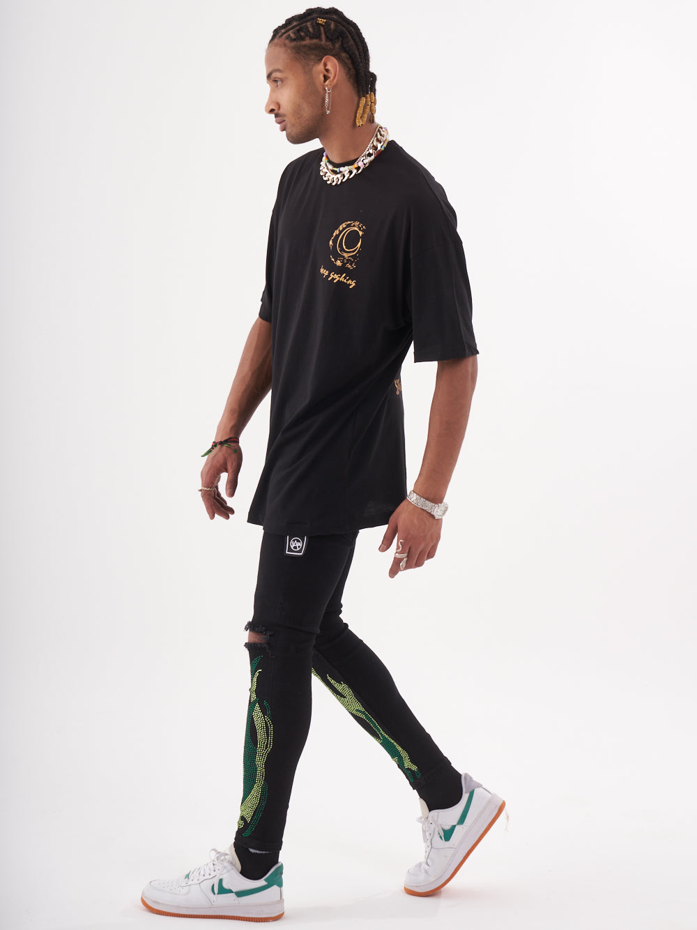 A man wearing a VINCENT T-SHIRT and green jogging pants.
