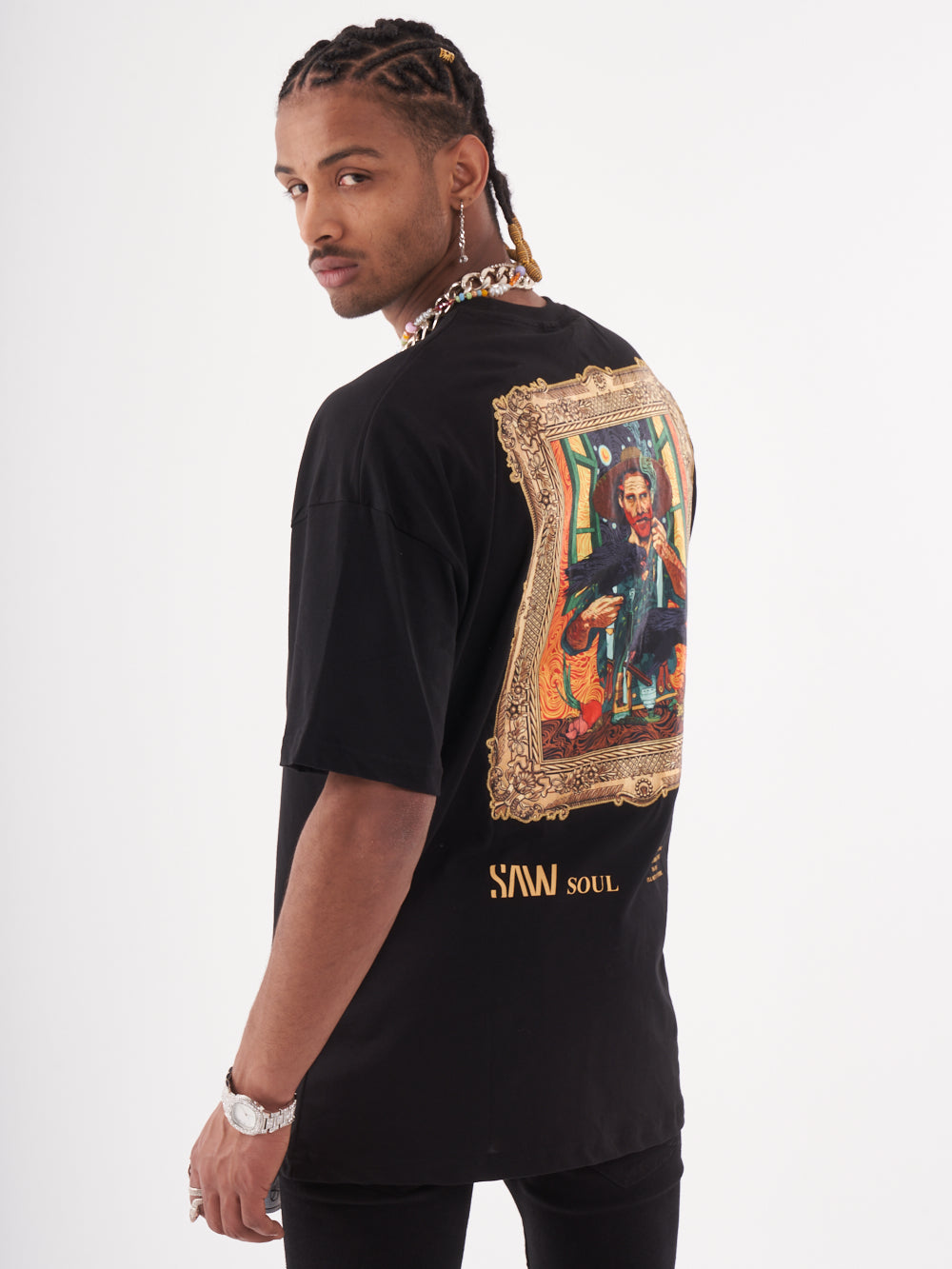 A man wearing a fashionable black VINCENT T-SHIRT with an art-inspired design.